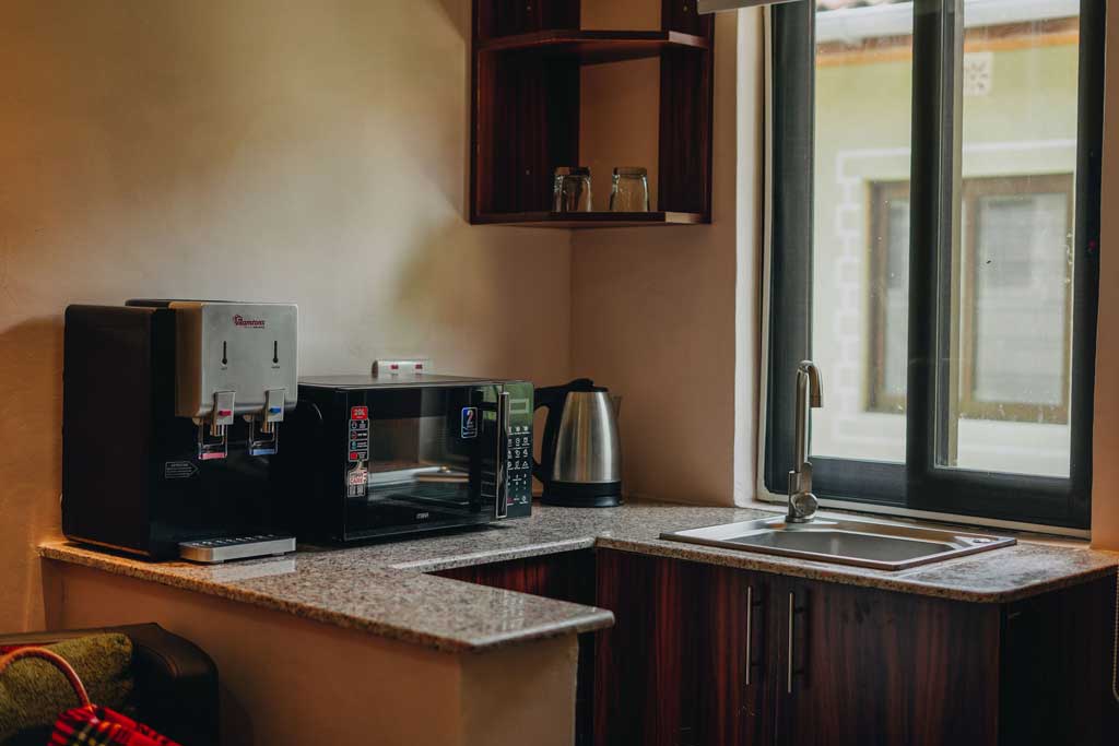 A private kitchenette with crockery, microwave, kettle, and water dispenser